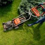 Gardener mowing lawn with push mower